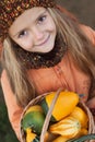 Little girl with a basketful of pumpkins