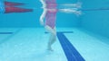 little girl bathes in a children's pool, view from under the water