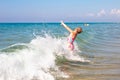 A little girl bathes in the waves of the sea. Fun and fun during the summer holidays Royalty Free Stock Photo