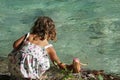 A little girl is bathing her doll in the Acheron River with its pristine nature in Epirus, Greece