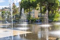 A little girl in a bathing suit plays in the water fountain spray at the Paillon Promenade in the city of Nice, France