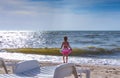 Little girl in a bathing suit, stands on the seashore Royalty Free Stock Photo