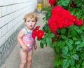 The little girl in a bathing suit is in the yard and with astonishment looks aside. Royalty Free Stock Photo