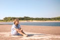 little girl on the beach with developing long blond hair in the wind and looking on the sea Royalty Free Stock Photo