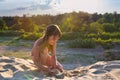 Little girl on the beach making a sand castle at sunset Royalty Free Stock Photo