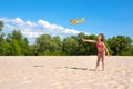 Little girl on beach shore is playing with a flying toy airplane. Children playing on the beach Royalty Free Stock Photo