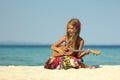Little girl on the beach with ukulele