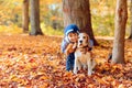 Little girl with beagle in the autumn park