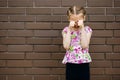 A little girl with a beautiful hairstyle is very upset and cries, wiping her eyes with her hands Royalty Free Stock Photo