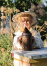 Little girl beekeeper blows smoker for bees