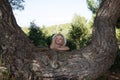 Little girl behind huge tree trunk Royalty Free Stock Photo
