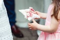 Little girl in a beige dress holding ring for the bride for the wedding ceremony in church