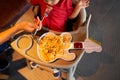 Little girl being fed pasta from a guitar-shaped plate on a high chair Royalty Free Stock Photo