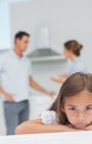 Little girl being sad while parents are quarreling Royalty Free Stock Photo