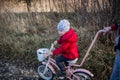 A little girl on a bicycle rides on a dirt dirt road. Ukrainian child immigrant Royalty Free Stock Photo