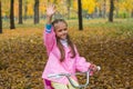 Little girl on a bicycle waving to someone a hand
