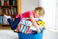 Little girl with a big basket of fresh clean laundry ready for ironing. Happy beautiful toddler and baby daughter Royalty Free Stock Photo