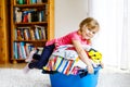 Little girl with a big basket of fresh clean laundry ready for ironing. Happy beautiful toddler and baby daughter Royalty Free Stock Photo