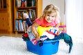 Little girl with a big basket of fresh clean laundry ready for ironing. Happy beautiful toddler and baby daughter Royalty Free Stock Photo