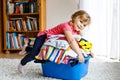 Little girl with a big basket of fresh clean laundry ready for ironing. Happy beautiful toddler and baby daughter Royalty Free Stock Photo