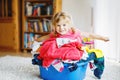 Little girl with a big basket of fresh clean laundry ready for ironing. Happy beautiful toddler and baby daughter Royalty Free Stock Photo