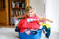 Little girl with a big basket of fresh clean laundry ready for ironing. Happy beautiful toddler and baby daughter Royalty Free Stock Photo