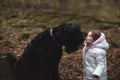 Little girl and big dog in the forest.