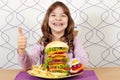 Little girl with big hamburger and thumb up Royalty Free Stock Photo