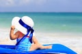 Little girl in big hat on summer beach