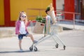 A little girl with a big trolley buys fresh food and vegetables in a big supermarket in the summer alone. Royalty Free Stock Photo