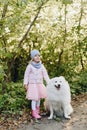 Little girl with a big white dog in nature Royalty Free Stock Photo