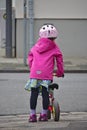 Little girl with bike helmet and balance bike waiting to cross the street Royalty Free Stock Photo