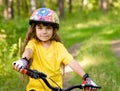 Little girl on bike looking at camera and smiling Royalty Free Stock Photo