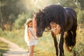 Little girl with black friesian stallion Royalty Free Stock Photo