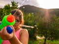 Little girl shooting water gun with the sun in the background Royalty Free Stock Photo