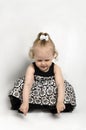 Little Girl in black and white dress sitting Royalty Free Stock Photo