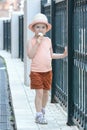 A little girl with blond hair goes and eats ice cream.