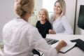 Little girl with blond hair with her mother at a doctor on consultation