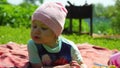 A little girl with blond hair is lying in a clearing