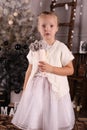 Little girl with blond hair wear elegant dress,posing beside Christmas tree Royalty Free Stock Photo