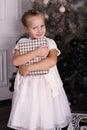 Little girl with blond hair wear elegant dress,posing beside Christmas tree Royalty Free Stock Photo