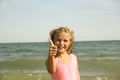 little girl blonde on the beach sand, sign class