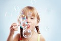 Little girl blowing bubbles