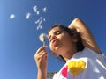 A little girl blowing dandelion seeds. Royalty Free Stock Photo