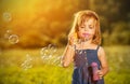 Little girl blowing soap bubbles in nature Royalty Free Stock Photo