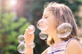 Little girl blowing soap bubbles in the park Royalty Free Stock Photo