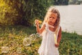 Little girl blowing soap bubbles in summer park. Child having fun Royalty Free Stock Photo