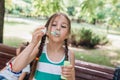 Little girl blowing soap bubbles in summer park Royalty Free Stock Photo