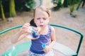 Little girl blowing soap bubbles in summer park Royalty Free Stock Photo