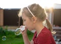 A little girl blowing soap bubbles in summer park. Royalty Free Stock Photo